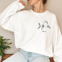 Looking for a thoughtful and personalized gift for the shark lover in your life? Our custom shark sweatshirt is the perfect choice! Featuring a variety of beautiful and majestic sharks, this cozy sweatshirt can be personalized with the recipient's favorite shark organization or even their own sharks name. Made from high-quality materials, this sweatshirt is perfect for staying warm and comfortable during chilly mornings on the farm or cozy evenings at home. Whether you're looking for a birthday gift or a special present for a loved one, our custom shark sweatshirt is sure to bring a smile to their face. Order yours today and show off your love for all things sharks in style! Materials - 50% Cotton  - 50% Polyester Processing time: 1-3 business days Shipping: 2-4 business days Thank you for White Crew Neck Top With Shark Design, Casual White Shark Design Tops, White Casual Tops With Shark Design, Casual White Tops With Shark Design, Shark Names, Shark Sweatshirt, Shark Lover, The Shark, White Sharks