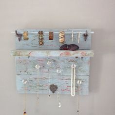 a wall mounted jewelry rack with several necklaces hanging from it