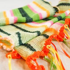 "Like tropical sunshine this boho chic fiesta citrus candy stripes beaded scarf will brighten your day and every outfit. Handmade scarf measures 11.5\" (29 cm) wide by 54\" (137 cm) long with 7\" (18cm) long fringe. Knit fabric scarf features bright green, leaf green, fuchsia, yellow and white stripes. Hand crocheted tangerine cotton thread finishes the ends. Fringe is created of lime, lemon and tangerine satin ribbons with golden yellow and tangerine beads tied to scarf ends. Long edges are slightly ruffled stitched with tangerine thread. *Wear with jeans, skirt or dress. *Tie as a sash with a skirt or dress. *Tuck in the neck of your jacket. *Wear over your favorite tee or sweater. To enjoy your scarf for years to come:  Hand wash. Cold water. Mild soap. Line dry.  To see my other scarve Handmade Summer Beach Scarves, Handmade Multicolor Scarves For Beach, Handmade Multicolor Scarves For The Beach, Handmade Multicolor Scarf For Beach, Yellow Bohemian Scarves For Festivals, Green Bohemian Scarf For The Beach, Bohemian Green Scarf For The Beach, Bohemian Yellow Scarves For Beach, Green Bohemian Scarf For Beach