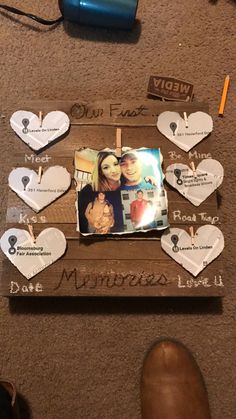 a couple's photo on a wooden frame with hearts attached to it