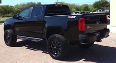 a black truck is parked in a parking lot