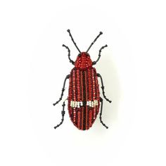 a red and black beaded bug on a white background