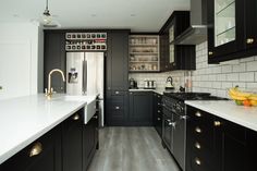 a kitchen with black cabinets and white counter tops