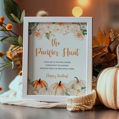 a white frame sitting on top of a wooden table next to pumpkins and flowers