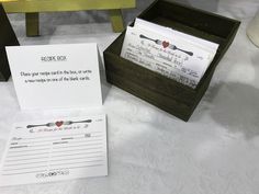 a wooden box with some writing on it next to a sign and a table cloth