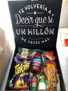 an open box filled with snacks and condiments next to a chalkboard sign