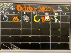 a chalk board with the dates for october and halloween written in orange, black, and white