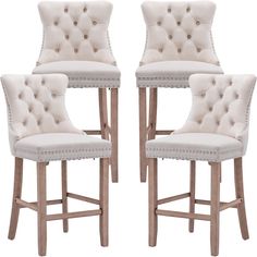 a set of four white upholstered barstools with buttons and studs