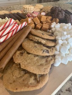 an assortment of cookies, marshmallows and candy canes