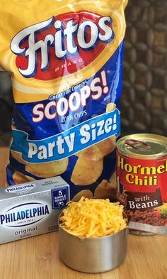 potato chips, parmesan cheese and other ingredients on a wooden counter top with a bag of potato chips in the background