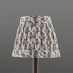 a lampshade with a lamp shade on it's base and an image of leaves printed on the fabric