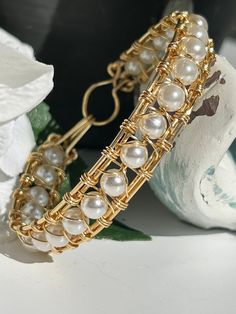 "This boho bangle bracelet is inspired by the pure and natural beauty of the beach.  In fact, many of the products in my shop are handmade on the beach while savoring the cool breeze and calming ocean sounds. The gemstone is a polished white cultured pearl which exhibits a glossy and lustrous appearance.  Pearls signify faith, charity and innocence.  They enhance personal integrity and help to provide a focus to ones attention.  Pearls symbolize purity and are known as \"stones of sincerity\". Pearl Bangles Gold, Wrapping Crystals, Boho Bangle Bracelets, Pearls Jewellery, Gemstone Bangle Bracelets, Personal Integrity, Angel Gabriel, Boho Bangle, Gemstone Bangle