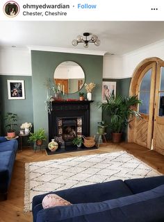 a living room filled with furniture and a fire place under a mirror on the wall