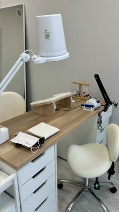 a desk with a chair, lamp and laptop on it