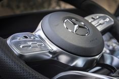 the steering wheel and controls of a car are shown in this close up photo,