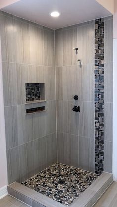 a walk in shower sitting next to a tiled wall