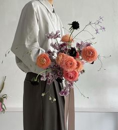 a woman holding a bouquet of flowers in her hands