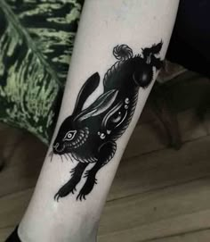 a black rabbit tattoo on the leg