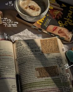 an open book sitting on top of a table next to a bowl of food and a cup of coffee