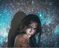 a woman standing in front of a wall with stars on it's face and body