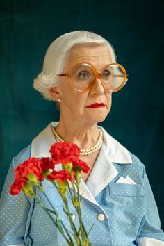 an older woman with glasses holding flowers