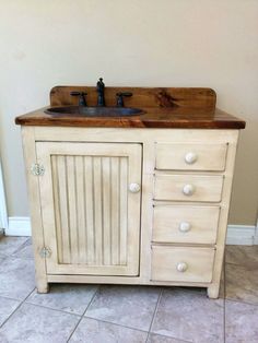 a bathroom vanity with drawers and a sink in the middle, on tile flooring