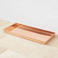 a wooden tray sitting on top of a tiled floor