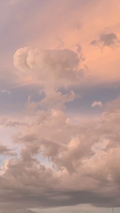 the sky is filled with clouds and there are two planes flying in the same direction