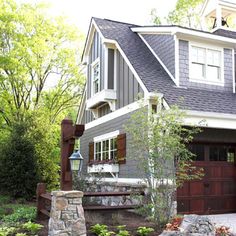 a house with a large garage and stone steps leading up to the front door area