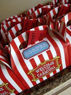 red and white striped boxes with welcome to the carnival written on them sitting on a counter