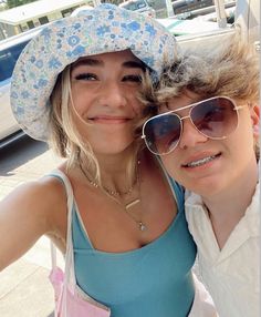 two women wearing hats and sunglasses posing for a photo