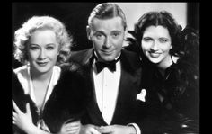 an old black and white photo of two women and a man in tuxedo