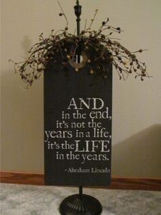 a sign that is on top of a stand with flowers in it and an image of abraham lincoln