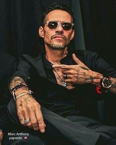 a man with tattoos sitting in a chair