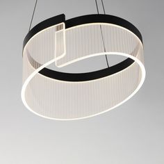 a circular light fixture hanging from the ceiling in a room with grey walls and flooring