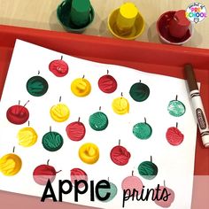 an apple printable is displayed on a tray with crayons and paints next to it