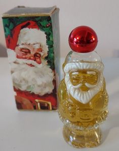 a glass santa clause figurine next to an old fashioned christmas greeting card box