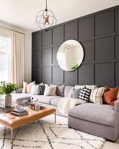 a living room filled with furniture and a large mirror on the wall above it's headboard