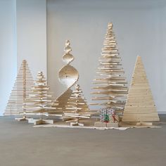 several wooden christmas trees in an empty room