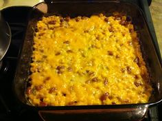 a casserole dish with cheese and meat in it on top of the stove