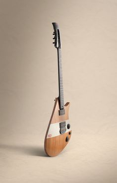 an electric guitar with a wooden body and neck is standing upright on a beige background