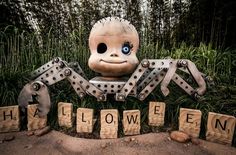 a large spider statue sitting in the middle of some blocks with words spelling it's halloween