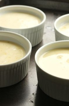 four bowls filled with soup sitting on top of a counter