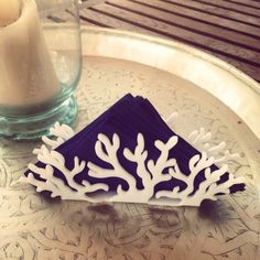 a blue and white piece of paper sitting on top of a table next to a candle