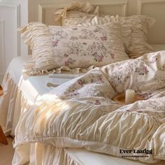 an unmade bed with ruffles and pillows on it, next to a lamp