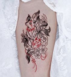 a woman's leg with a tattoo on it that has an image of a fox and flowers