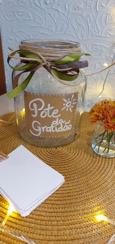 a glass jar with some lights around it and a notepad on the table next to it