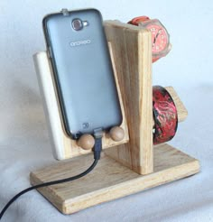 a cell phone is plugged into a wooden holder