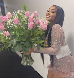 a woman holding a bouquet of pink roses