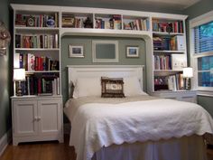 a bedroom with bookshelves and a bed in it